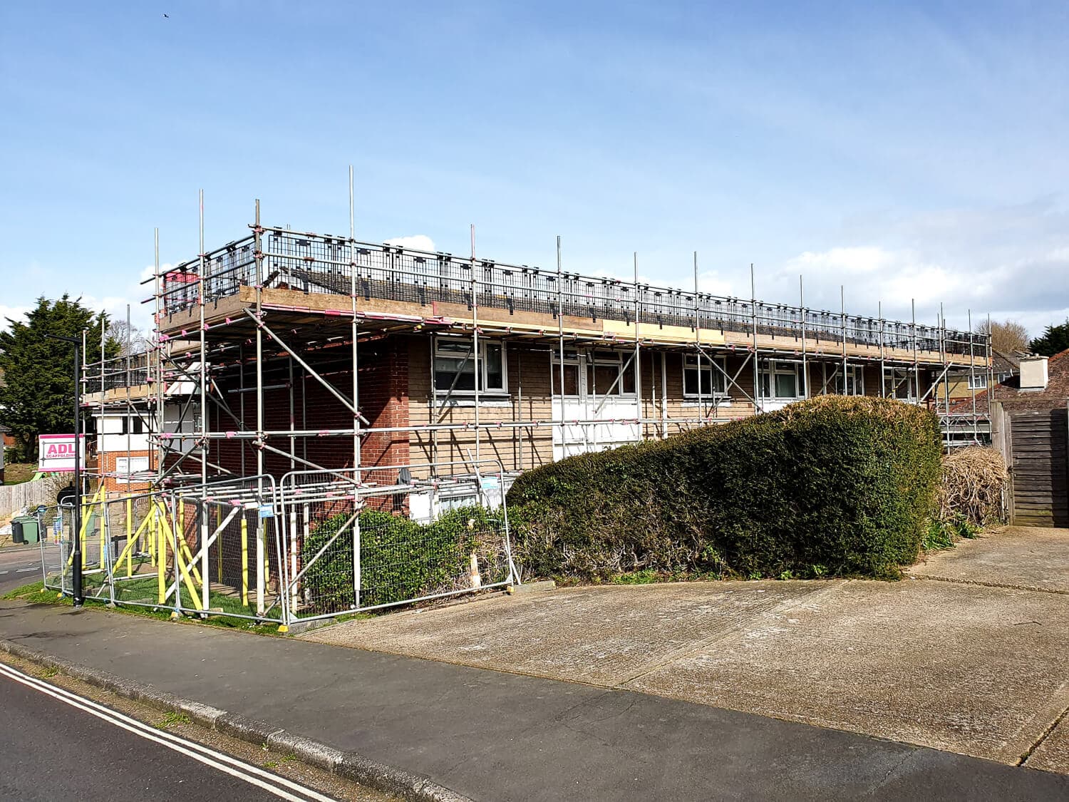 Full scaffolding along a row of residential properties for roof replacement, Isle of Wight