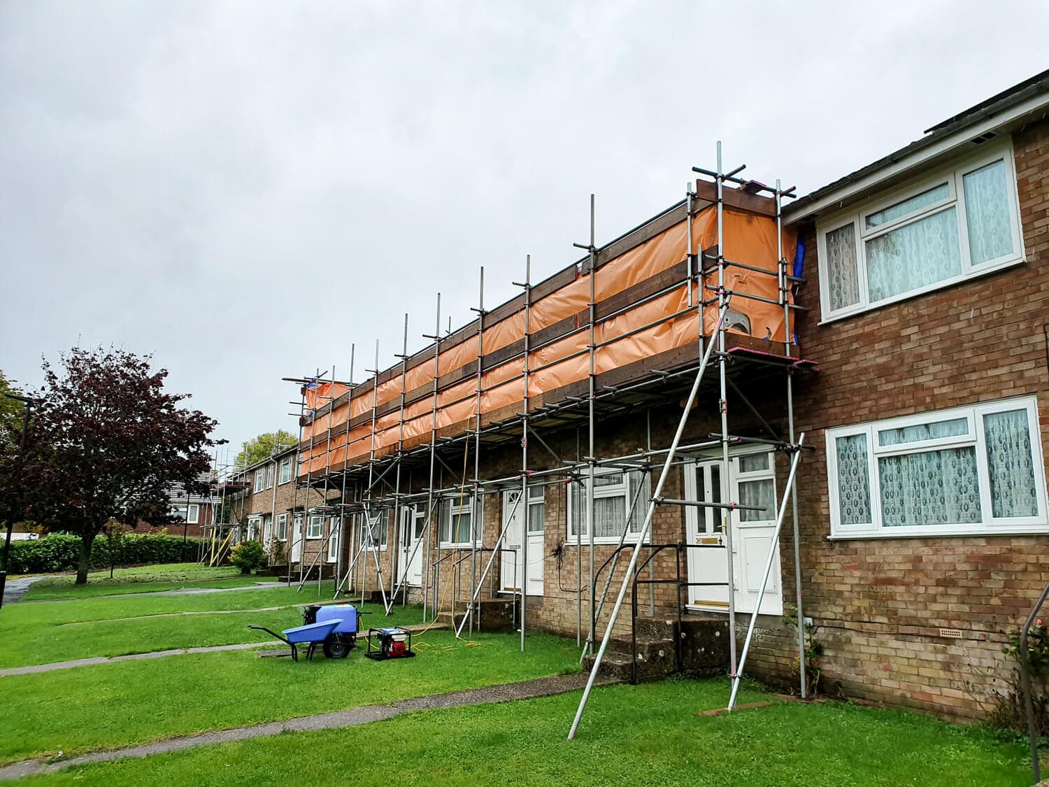 Scaffolding erected across a row of residential houses for roof and guttering works, Isle of Wight