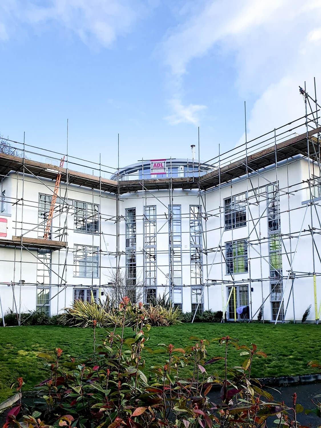 Full scaffolding on a large white residential building for exterior repairs, Isle of Wight