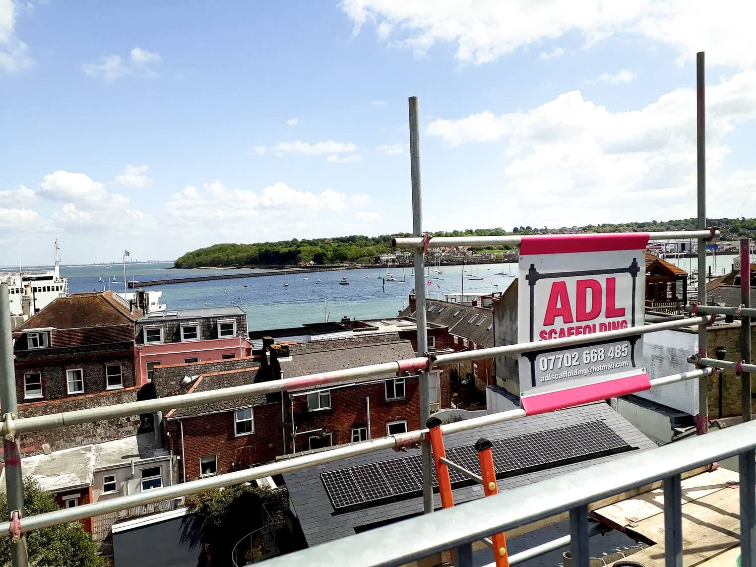 View over Cowes harbour from scaffolding with ADL Scaffolding signage, Isle of Wight