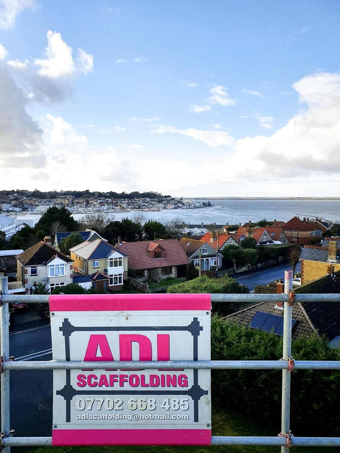 ADL Scaffolding sign on a coastal residential job with views over the Solent, Isle of Wight