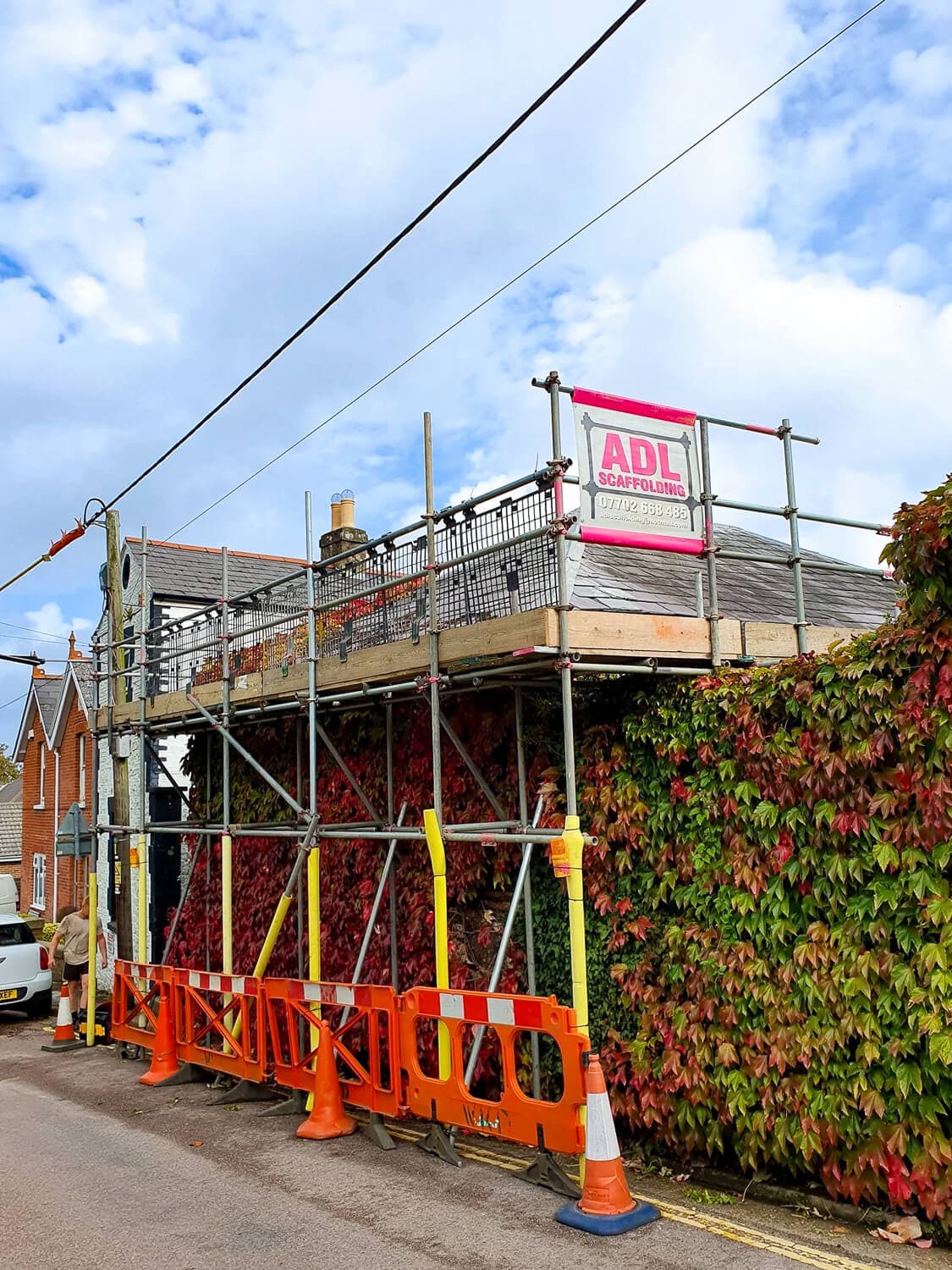 Residential property scaffolding alongside an ivy-covered wall, Isle of Wight