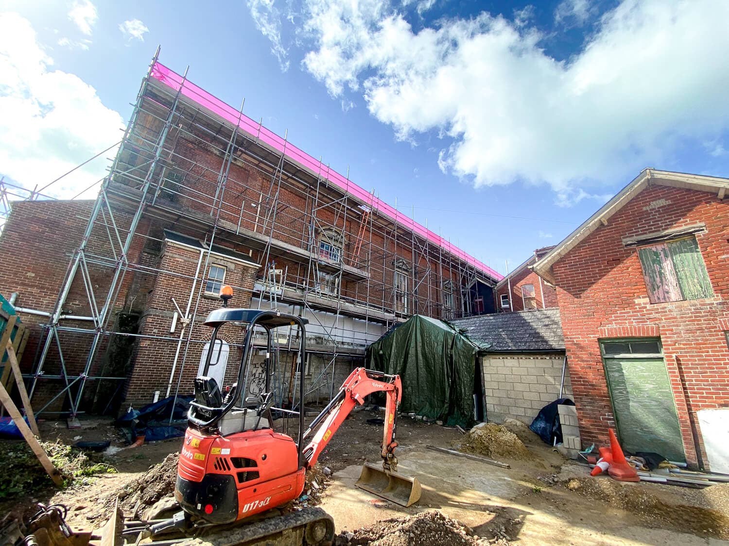 Scaffolding on a large brick commercial building with construction work underway, Isle of Wight